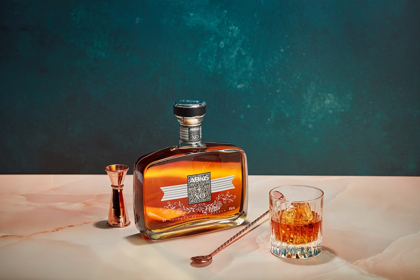A bottle of alcohol next to a glass of alcoholDescription automatically generated