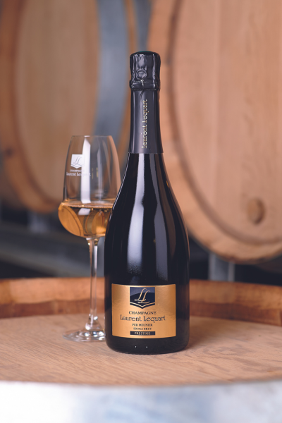 A bottle of wine next to a glass of wineDescription automatically generated