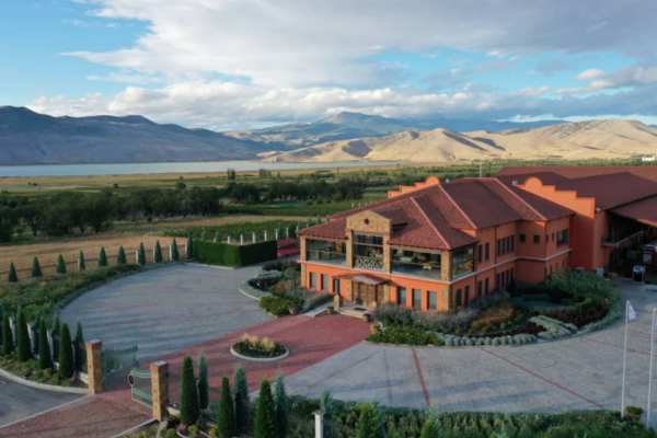 A large house with a large driveway and treesDescription automatically generated